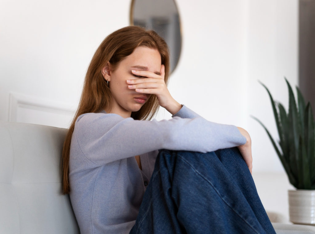 Mulher com a mão no rosto inconsolada 